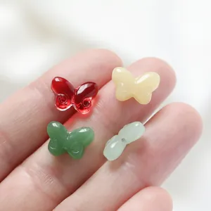 Close-up of colorful glass butterfly beads with through-holes for DIY jewelry