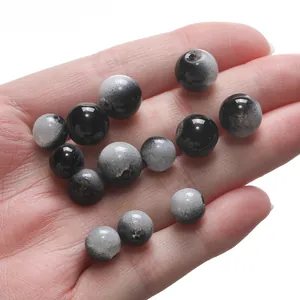 Macro detail of gradient black and grey glass beads held in hand for DIY jewelry