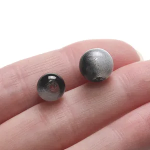 Macro view showing two black and speckled gray glass loose beads for DIY jewelry crafting.