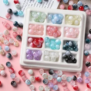 Macro detail of colorful crackle glass beads in a white sorting tray for DIY crafts