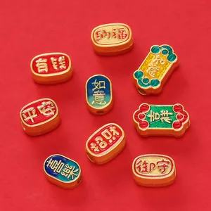 Detailed view of traditional Chinese gold spacer beads with colorful enamel and blessing characters