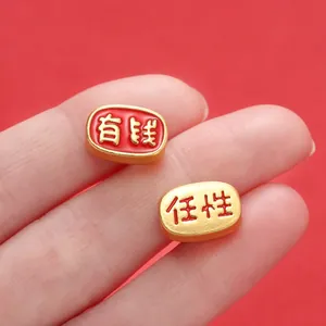 Detailed macro shot of Chinese style gold spacer beads with red enamel and auspicious characters
