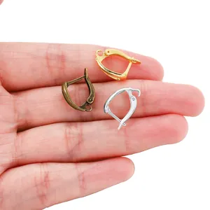 Drei Brisuren-Ohrhaken in Gold, Silber und Bronze auf einer Hand zur Größenansicht.