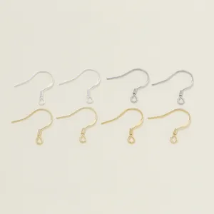 Macro detail of gold and silver plated fishhook earring wires for DIY jewelry making.