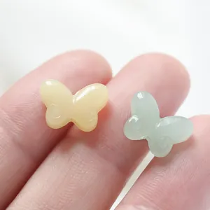 Close-up detail of small colored glaze butterfly beads for DIY jewelry making accessories