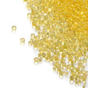 Detailed macro view of yellow iridescent glass bubble beads for DIY jewelry and nail art crafts