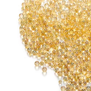 Macro close-up of iridescent amber glass bubble beads for DIY jewelry and nail art accessories