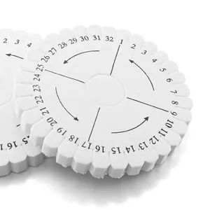 Gros plan d'un disque de tressage Kumihimo blanc avec fentes numérotées pour bijoux.