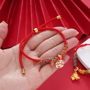 Close-up of a handmade red string bracelet featuring a small horse charm and colorful weave.