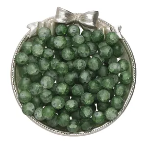 Macro view of green frosted crackle glass beads piled on a decorative silver bow tray