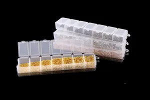 Detail van diverse legering afstandsparels in transparante plastic doosjes.