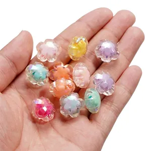 Détail macro de perles de fleurs en acrylique irisées à cinq pétales pour bijoux DIY.