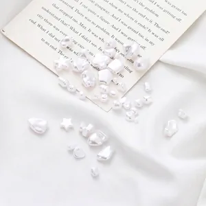 Dettaglio di perle finte in ABS bianco di varie forme per gioielli fai da te