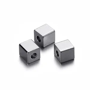Macro detail of three polished stainless steel square spacer beads for DIY jewelry
