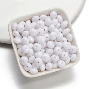 Vue détaillée macro de perles plates en acrylique facetté blanc pour bijoux DIY.