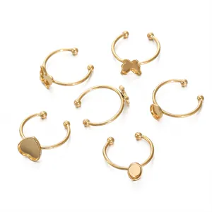 Detailed view of gold-plated stainless steel DIY ring blanks in heart and butterfly shapes