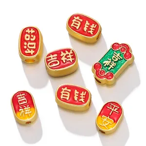 Macro view of ancient gold Chinese charms with red and green enamel blessings