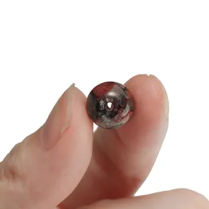 Detailed view of a 10mm red and black floral glass bead with gold glitter for DIY crafts