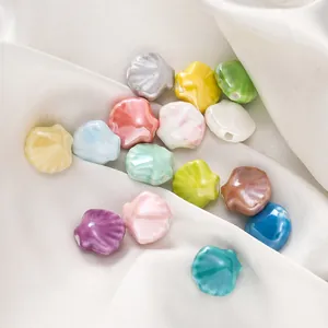 Detail van kleurrijke keramische kralen in schelpvorm voor DIY-sieraden maken.