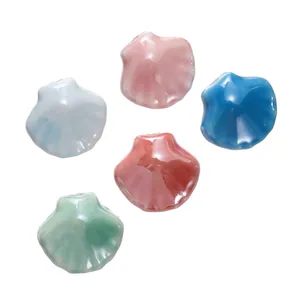 Gedetailleerd overzicht van kleurrijke keramische schelpkralen voor DIY sieraden.