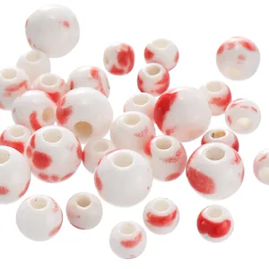 Macro view of white and red splatter patterned round ceramic beads for DIY jewelry