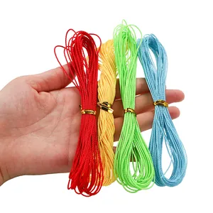 Detail view of a hand holding four colorful 1mm braided wax cords for DIY jewelry.