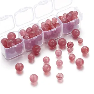 Detailansicht von rosa Erdbeerkristallperlen für DIY-Schmuck in einem Behälter.
