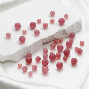 Makro-Detailansicht natürlicher rosa Erdbeerkristall-Rundperlen für DIY-Schmuckherstellung