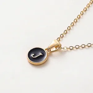 Elegante goldene minimalistische Kette mit einem schwarzen Emaille-Buchstaben J Anhänger