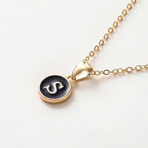 Minimalistische Goldkette mit einem runden schwarzen Emaille-Anhänger mit dem Buchstaben S