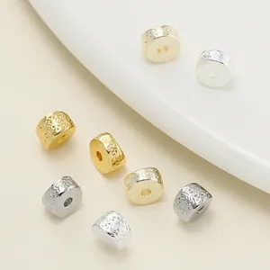 Detailed macro view of 18K gold and silver plated textured spacer beads for DIY jewelry making.