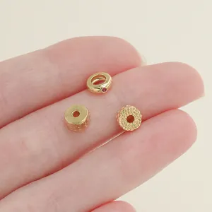 Detailed view of three 18k gold-plated spacer beads with textured patterns and zircon