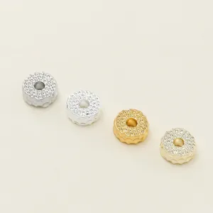 Close-up detail of textured metal spacer beads in gold and silver finishes for jewelry