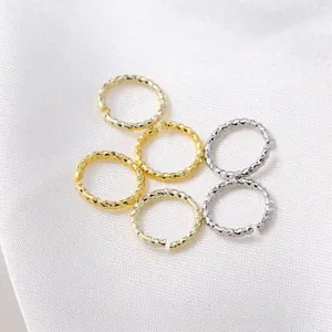 Set of textured DIY jewelry jump rings in 14K gold and silver finishes on white silk