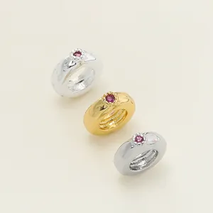 Macro detail of hammered metallic spacer beads with pink gemstones for jewelry DIY.