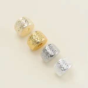 Close-up of DIY spacer beads with intricate embossed floral patterns in gold and silver