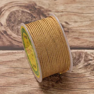 Close-up of golden 2.5mm braided jewelry cord wound on a spool for DIY crafts