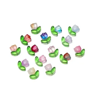 Macro view of colorful translucent glass tulip flower and leaf beads for DIY jewelry making.
