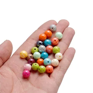 Détail macro de perles rondes en acrylique nacré de 10mm pour la création de bijoux DIY