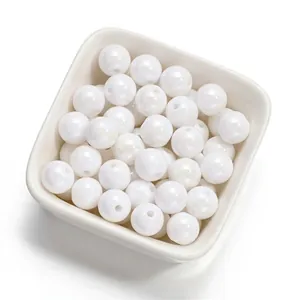 Détail de perles rondes en acrylique blanc irisé de 10 mm pour la création de bijoux DIY