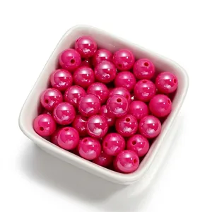 Gros plan de perles en acrylique fuchsia de 10 mm avec un fini nacré pour bijoux DIY.