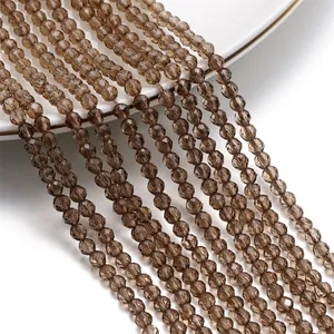 Primo piano di perline rondelle in cristallo sfaccettato marrone da 3 mm per gioielli fai da te.