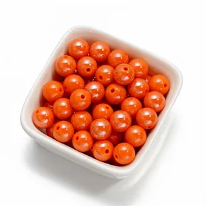 Gros plan de perles rondes en acrylique orange de 10 mm pour création de bijoux