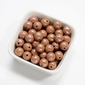Vue détaillée de perles rondes en acrylique marron de 10 mm pour bijoux DIY.