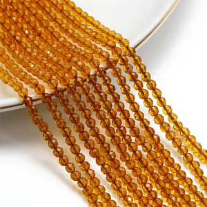 Dettaglio macro di perle di cristallo rondelle sfaccettate ambra da 3mm per gioielli DIY