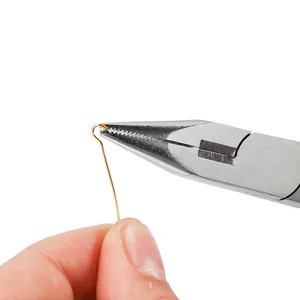 Precision needle nose pliers bending a gold metal wire for jewelry making craft