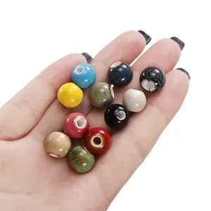 Close-up of assorted colorful ceramic beads for DIY jewelry making on a human hand