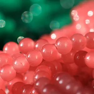 Primer plano de cuentas de vidrio rosa de 10 mm para la creación de bisutería DIY