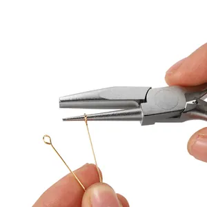 Close-up view of precision jewelry pliers bending a thin gold metal craft wire for DIY