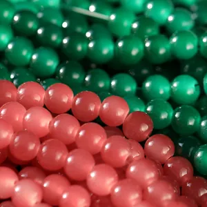Detalle macro de cuentas de vidrio rosas y verdes de 10mm para accesorios de joyería DIY